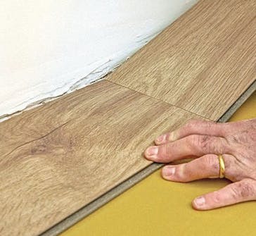 Isoleret anneks: Klikgulv i isoleret anneks Isoleret anneks: Den første række klikgulv lægges i isoleret anneks